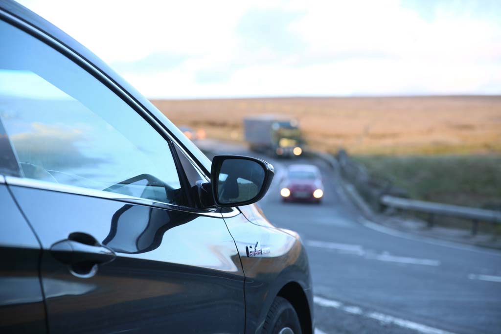 Car waiting at junction on country road