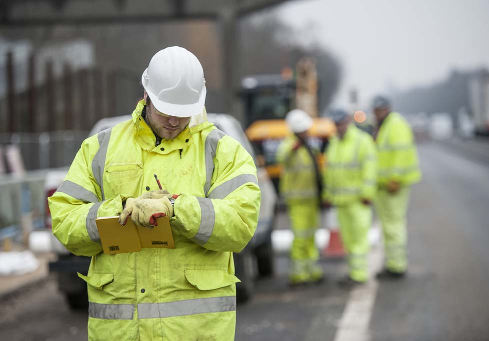Road construction workers making note and discussing