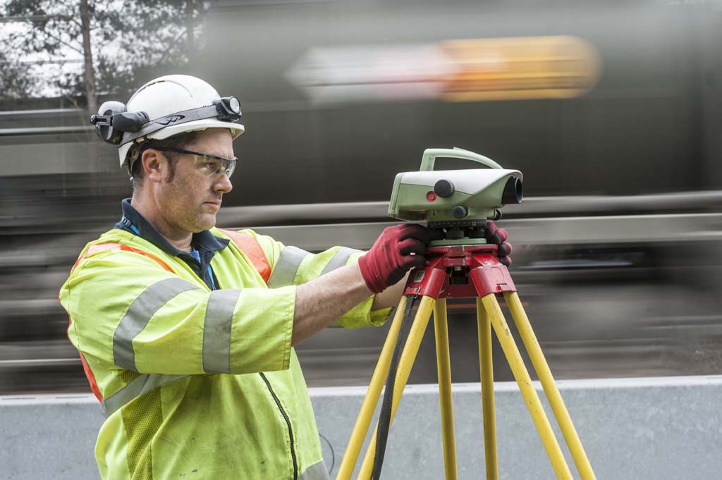 Male construction worker using EDM Electronic distance measuring tool