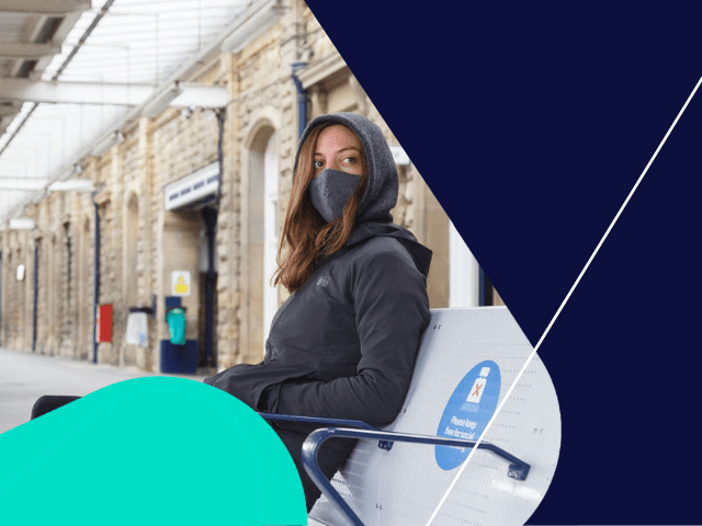 Female masked waiting at station on bench